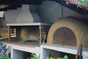 an outdoor pizza oven with a brick wall at Alexandra's Relaxing House in Mikrománi