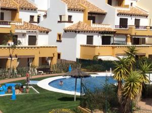 a hotel with a swimming pool in front of a building at Costa Esuri Ayamonte Apartment in Ayamonte