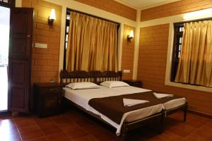 a bedroom with a large bed and a window at Dazzle Dew in Alleppey