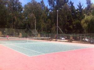 two people playing tennis on a tennis court at Bahía Pelicanos Catalina in Ventanas