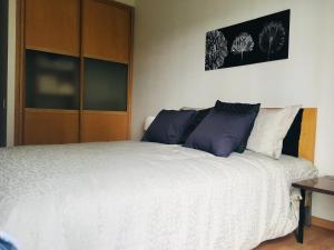 1 dormitorio con cama blanca y almohadas azules en Apartment Down Town 422, en Ciudad de México