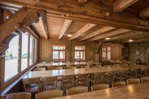 a large room with wooden tables and chairs at juhui Flumserberg in Flumserberg