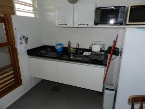 una pequeña cocina con fregadero y nevera. en Residencial Pontal do Jurerê, en Florianópolis