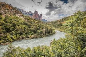 une rivière traverse un canyon avec des falaises dans l'établissement Atardeceres d'Aragón, à Fontellas