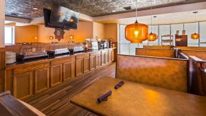 ein Esszimmer mit einem Tisch und einer Bar in der Unterkunft Baymont by Wyndham Groton/Mystic in Groton