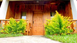 a wooden front door of a house with two trees at Belcruz family lodge in Monteverde Costa Rica