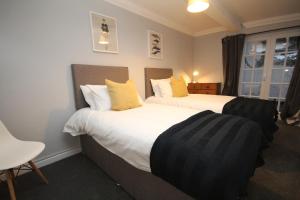 a hotel room with two beds with yellow pillows at The Garden Apartment in Leamington Spa