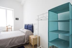 una camera da letto con una mensola blu accanto a un letto di PrimoPiano - Astolfo 12 a Milano