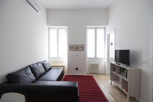 uma sala de estar com um sofá preto e uma televisão em PrimoPiano - Astolfo 12 em Milão