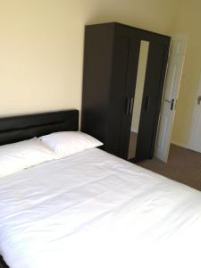 ノリッジにあるStayNorwich 69G - Globe Viewのベッドルーム(白いベッド1台、黒いキャビネット付)