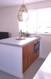 a kitchen with a white counter and a window at INTIKA Beach House in Zandvoort