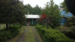 una casa con un camino de tierra delante de ella en Cabana Caburgua, en Caburgua