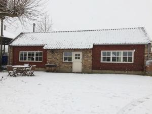 una casa di mattoni rossi con neve sul tetto di B&B Ool Inclusive a Roermond