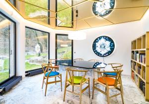 comedor con mesa, sillas y ventanas en Villa an der Loreley en Sankt Goar