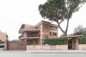 a house with a tree in front of it at Peperino Attic Flat in Ciampino