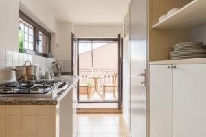 a kitchen with a stove and a view of a patio at Peperino Attic Flat in Ciampino