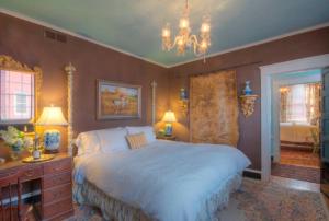 um quarto com uma cama grande e um lustre em Inn at Court Square em Charlottesville