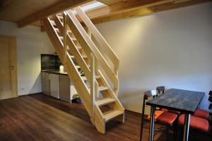 a staircase in a room with a table and a kitchen at U jezera Laka in Prášily