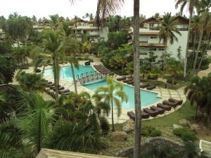 an aerial view of a resort pool with lounge chairs and palm trees at Xeliter Balcones del Atlantico - Las Terrenas in Las Terrenas +243 photos
