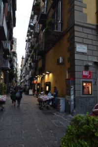 una calle de la ciudad con gente caminando por la calle en B&B La Movida, en Nápoles