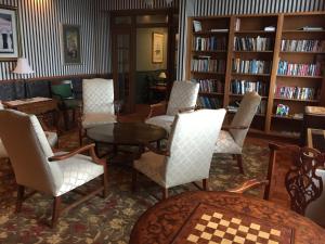 une bibliothèque avec des chaises, une table et des étagères dans l'établissement Stafford's Perry Hotel, à Petoskey