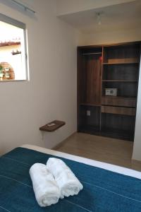 a room with a bed with two white towels on it at Pousada Brisa do Mar in Aquiraz