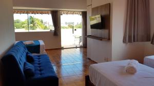 a living room with a blue couch and a tv at Pousada Brisa do Mar in Aquiraz