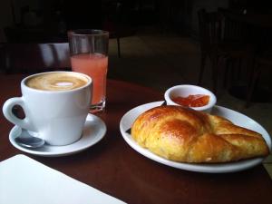 una taza de café y un cruasán sobre una mesa en Hotel El Doncel, en Atarfe