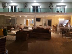 a living room with a couch and a dining room at Casa de Oliveira Pousada in Torres