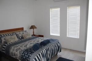 a bedroom with a bed and two windows at 41 The Bridge in St Lucia