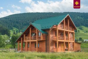 a large wooden house with a green roof at Плай in Verkhovyna +45 photos
