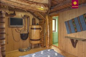 a room with a tv and a wooden cabin at Плай in Verkhovyna
