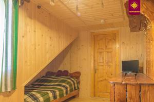 a room with a staircase with a bed and a television at Плай in Verkhovyna