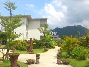 una casa con giardino alberato e piante di Phukamala Suite a Kamala Beach