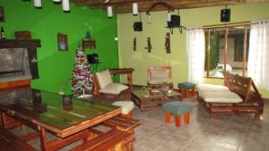 a living room with a christmas tree and a green wall at Cabañas Las Bahienses in San Rafael