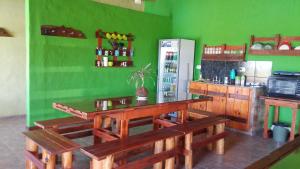 a green kitchen with wooden tables and a refrigerator at Cabañas Las Bahienses in San Rafael