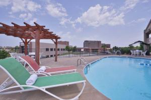 una piscina con sillas, una sombrilla y una piscina en The Bradford Hotel, Ascend Hotel Collection, en Springfield
