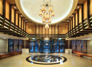 a lobby with a chandelier and a fountain in the middle at Sun Moon Lake Hotel in Yuchi
