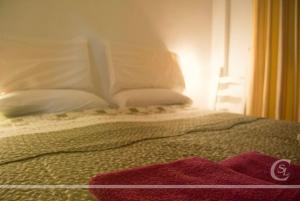 Una cama con almohadas blancas y una manta roja. en Cabañeros San Luis in 