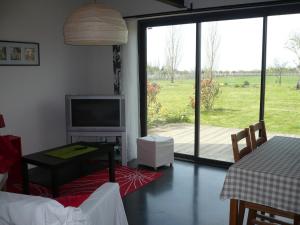 a living room with a tv and a large window at Gites Gayet in Saint-Androny