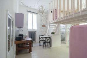 a kitchen and dining room with a table and a staircase at New loft in the heart of Bologna in Bologna