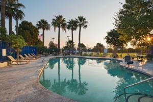 una gran piscina con palmeras en un parque en Stevens Inn a Howard Johnson by Wyndham, en Carlsbad