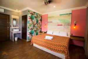 a bedroom with a bed with a colorful wall at Hotel All Riviera in Playa del Carmen