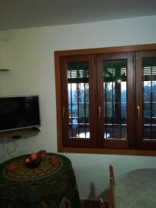 a room with a table and a tv and some windows at Cortijo El Cerrillo in Granada