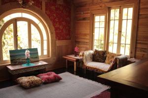 a living room with a couch and a table and windows at Loft del Rio in Cajon del Maipo