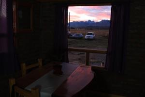 una mesa y una ventana con vistas a un campo en Los Tres Picos en Cholila