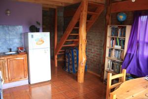 cocina con nevera y estante para libros en Los Tres Picos en Cholila