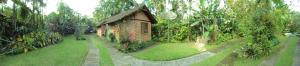 a garden with a small brick house and trees at Pousada Itupava in Morretes