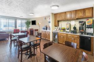 a kitchen with a table, chairs and a refrigerator at Super 8 by Wyndham North Sioux City in North Sioux City