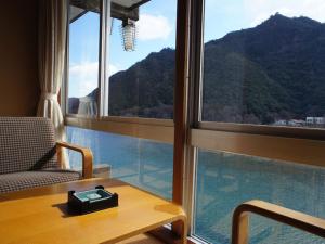 a room with a table and a view of a mountain at Usyounoie Sugiyama in Gifu